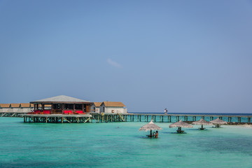 Maldives, Feb 8th 2018 - Tourists enjoying a calm beach, blue water, tropical climate, no waves in a blue sky day in Maldives.