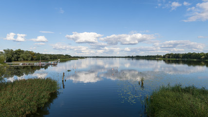 Blick auf einen See mit Wolken vor blauem Himmel