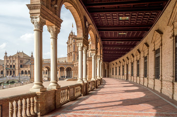 Fototapeta premium The porticoed gallery and hallway with columns and tiled floor in Plaza de Espana, Seville Spain