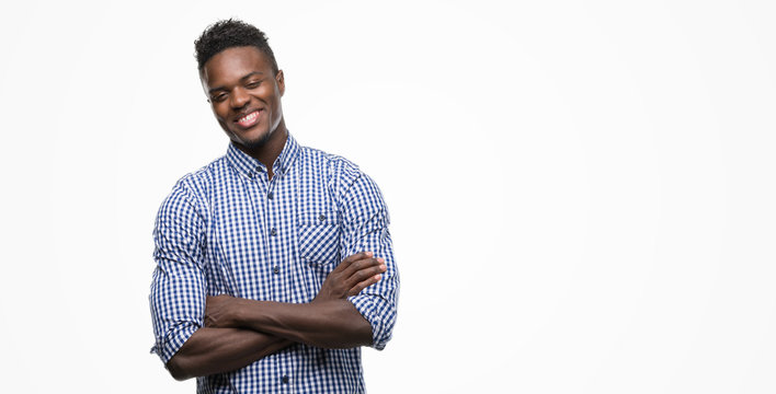 Young African American Man Wearing Blue Shirt Happy Face Smiling With Crossed Arms Looking At The Camera. Positive Person.