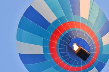 Fototapeta premium Close up of a colorful hot air balloon in blue sky. Bottom view.