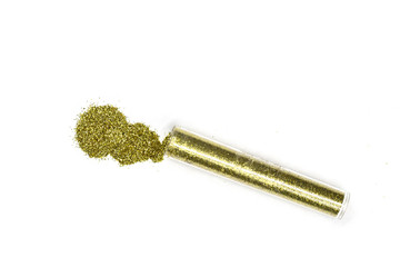 Gold glitter in transparent plastic tube on white background. Yellow gold powder decor isolated. Cosmetic gold shimmer