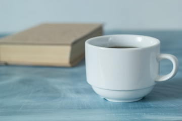 A cup of coffee and a book. 