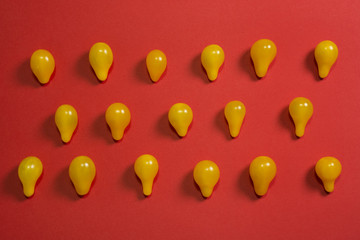 Creative food background. Yellow cherry tomatoes on red background top view