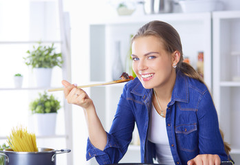 Young woman cooking healthy food holding a pan with vegetables is it. Healthy lifestyle, cooking at home concept