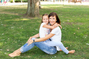 daughter and father on the lawn.in a white t-shirt and jeans. a walk in the Park. child. father and daughter. summer.