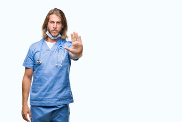 Young handsome doctor man with long hair over isolated background doing stop sing with palm of the...