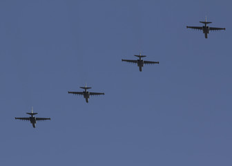 Several military fighters are flying in a formation against the blue sky
