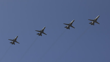 Fototapeta na wymiar Several military fighters are flying in a formation against the blue sky