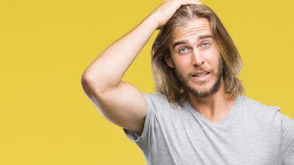 Young handsome man with long hair over isolated background holding football ball stressed with hand...