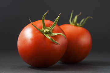 Group of tomatoes isolated on black with leaf and stem. There are around 7,500 tomato varieties grown for various purposes.Tomato varieties can be divided into categories based on shape and size.