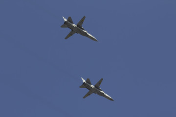 Several military fighters are flying in a formation against the blue sky