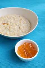 Porridge and orange jam or marmalade for morning breakfast on bright table