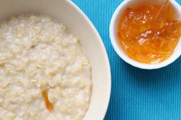 Porridge and orange jam or marmalade for morning breakfast on bright table