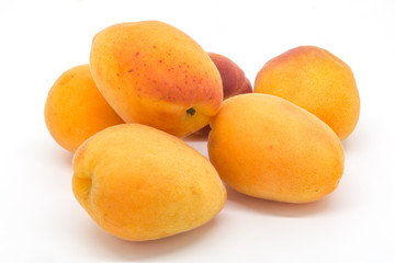 A group of fresh apricots against a white background