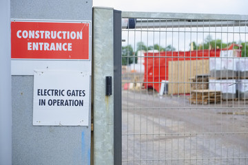 Electric gates in operation at construction site entrance sign