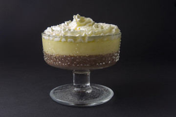 Mousse, souffle, pudding with vanilla and chocolate in glass black, dark background.