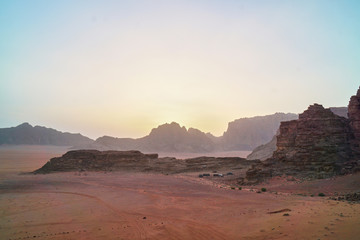             Sunset time rocks in Wadi Rum desert (The Valley of the Moon). Jordan, Middle East.  Red sands, sky with haze. Designation as a UNESCO World Heritage Site.