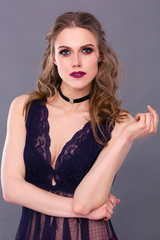 Fototapeta premium Beautiful young woman in evening dress on black background.