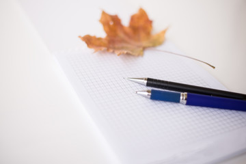 background with notebook, pencil, pen, maple leaf and copy space (horizontally )
