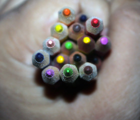 Hand holding colorful wooden pencils. Memory of childhood. Back to school.
