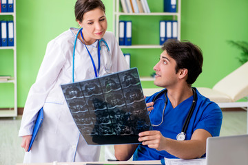 Woman and man gynecologists discussing medical case at the clini