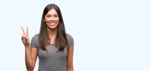 Young beautiful hispanic woman showing and pointing up with fingers number two while smiling confident and happy.