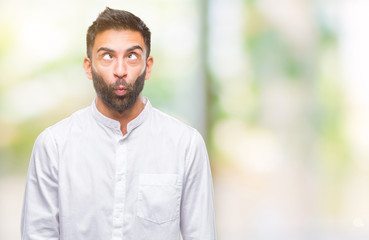 Adult hispanic man over isolated background making fish face with lips, crazy and comical gesture. Funny expression.