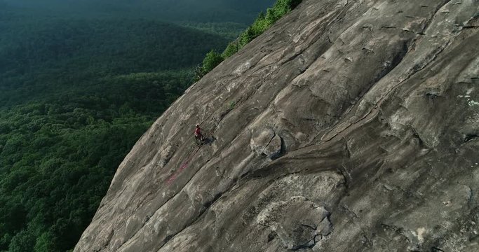 Aerial, people climb side of Looking Glass Rock