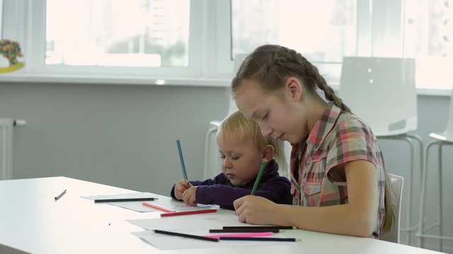 Two little girls are drawning