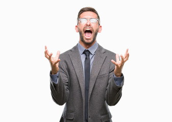 Young handsome business man over isolated background crazy and mad shouting and yelling with aggressive expression and arms raised. Frustration concept.