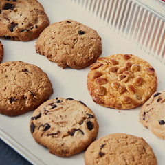 Close-up of homemade peanut biscuits with chocolate chunks for dieting vegan eat on a baking sheet.