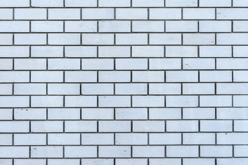 texture of a wall from a natural white brick with small cracks and chips, close-up abstract background