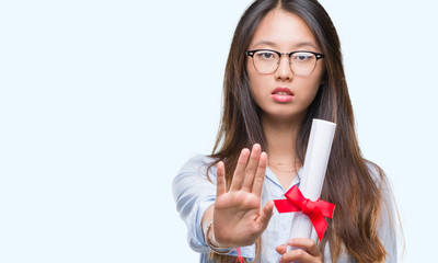 Young asian woman holding degree over isolated background with open hand doing stop sign with...