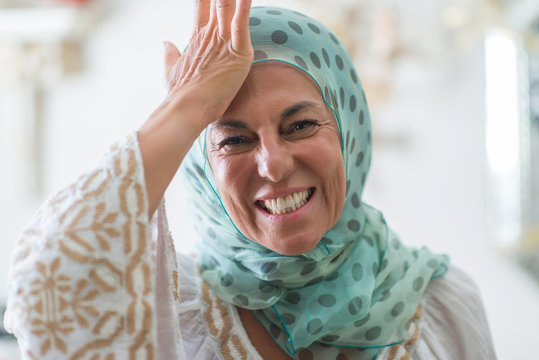 Middle age brunette arabian woman wearing colorful hijab stressed with hand on head, shocked with shame and surprise face, angry and frustrated. Fear and upset for mistake.