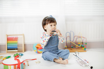 baby girl play harmonica at home
