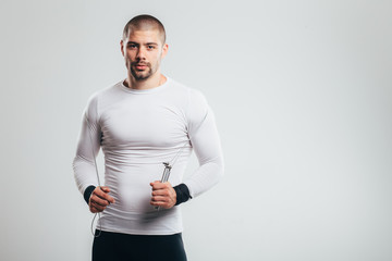 Fit and muscular man with jumping rope/ Fit muscular man posing at studio