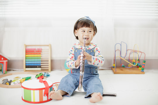 Baby Girl Play Trumpet At Home