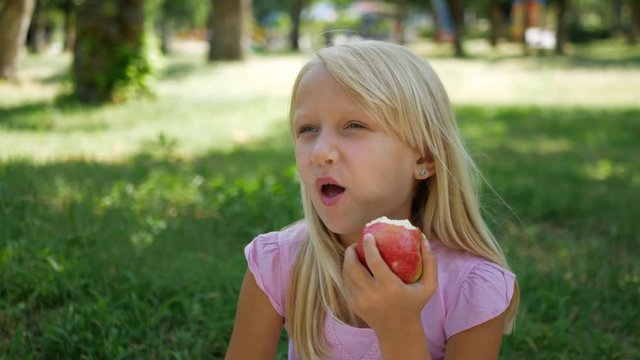 girl bites sour apple