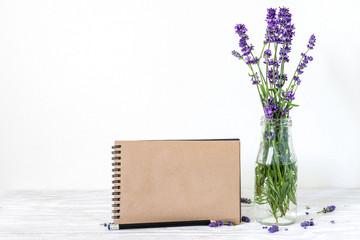 creative mock up with a beautiful bouquet of lavender flowers and blank hipster notebook with place...
