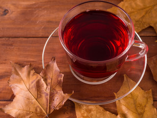 Cup of tea surrounded by autumn leaves.