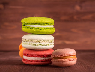 Colorful and tasty macaroons on a wooden background.