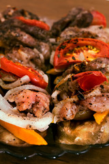 Beautifully laid on a plate baked eggplant with a top layer of roasted meat with tomatoes, carrots and onions, close-up, vertical frame.