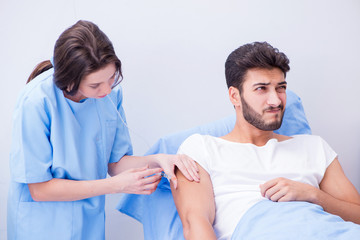 Woman doctor examining male patient in hospital