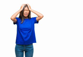 Young asian woman over isolated background suffering from headache desperate and stressed because pain and migraine. Hands on head.