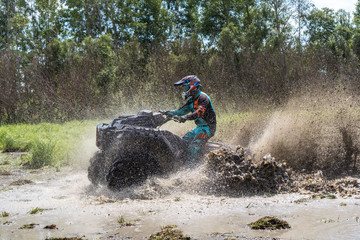 ATV Quad rides fast on big dirt and makes splashes of dirty water © suvorovalex