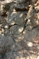 Granite rocks in the sun. Texture of granite stone. Background of natural material. Rocky rocks of ancient times