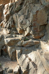 Granite rocks in the sun. Texture of granite stone. Background of natural material. Rocky rocks of ancient times