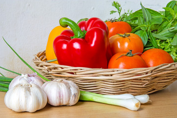Organic vegetables in the wicker basket on wooden background