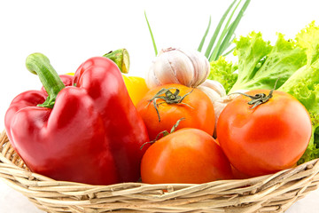 Organic vegetables in the wicker basket on white background